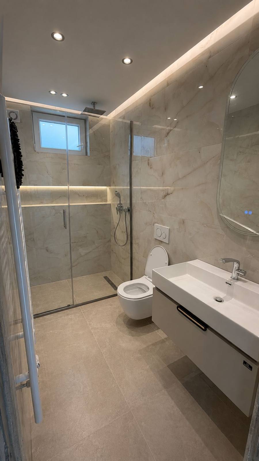 Modernes Bad mit Marmorfliesen, Glasdusche und LED-Beleuchtung