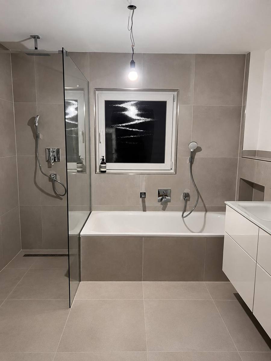 Modernes Bad mit Glasdusche, Badewanne und Wandarmaturen